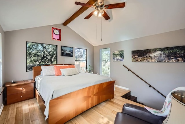 bedroom featuring multiple windows, light wood-type flooring, lofted ceiling with beams, and ceiling fan