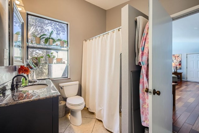 bathroom featuring tile patterned floors, vanity, toilet, and walk in shower