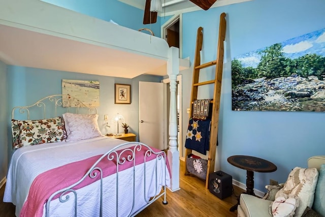 bedroom with hardwood / wood-style flooring and beamed ceiling