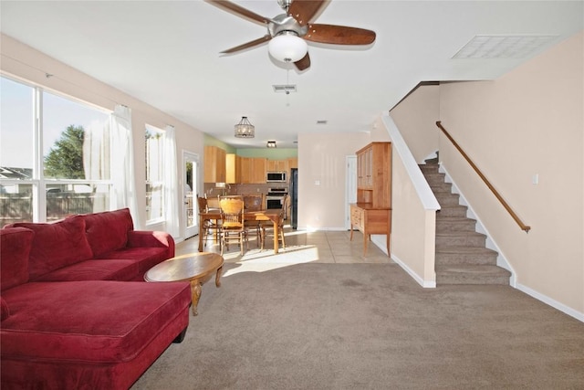 carpeted living room featuring ceiling fan