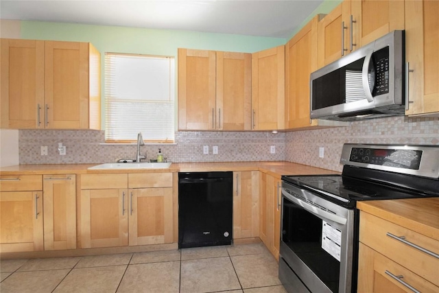 kitchen featuring backsplash, sink, light tile patterned floors, and stainless steel appliances