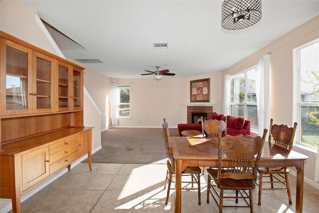 dining room with ceiling fan, light tile patterned floors, and a fireplace