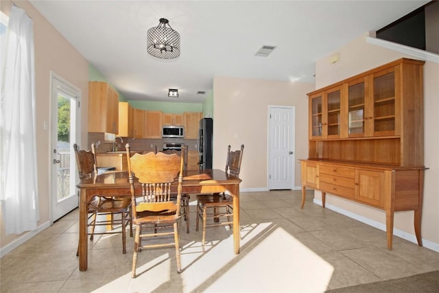 tiled dining room featuring sink