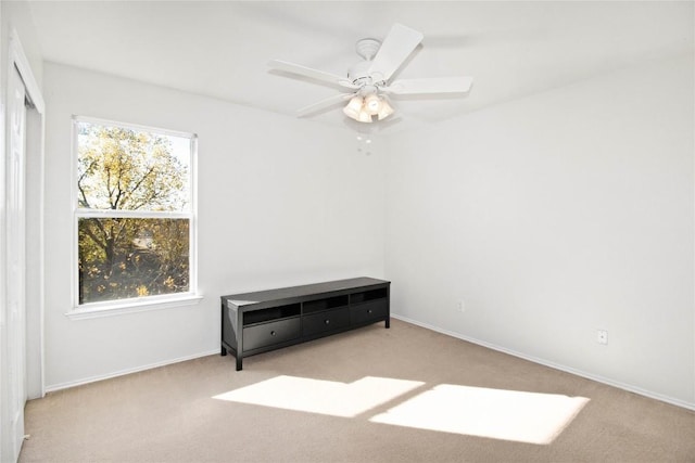 carpeted empty room featuring ceiling fan