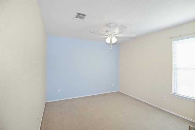 spare room with ceiling fan and light colored carpet