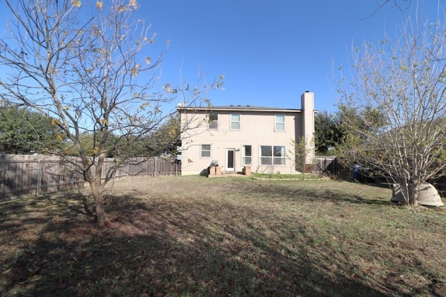 rear view of property featuring a lawn