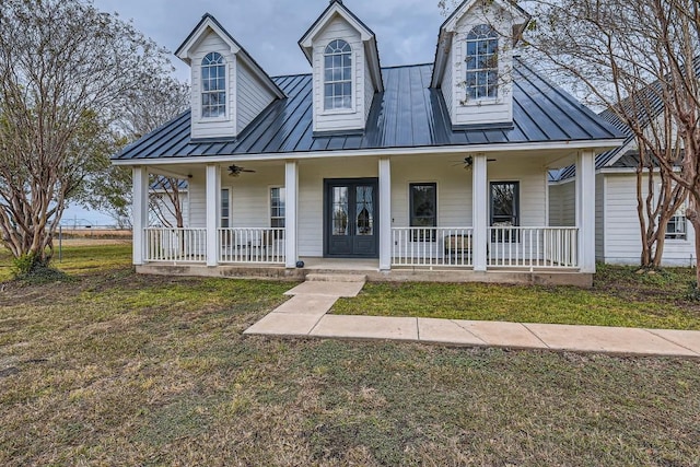 view of front of property with covered porch, a front yard, and french doors