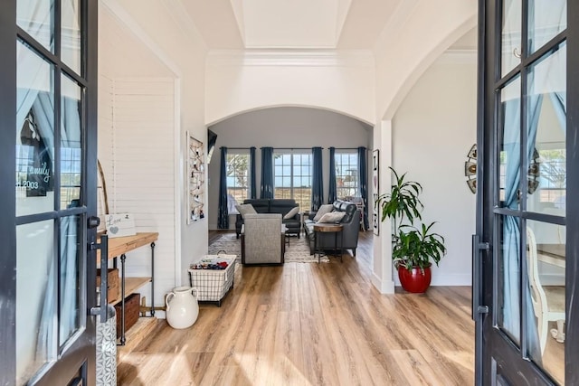 foyer entrance with ornamental molding and light wood-type flooring