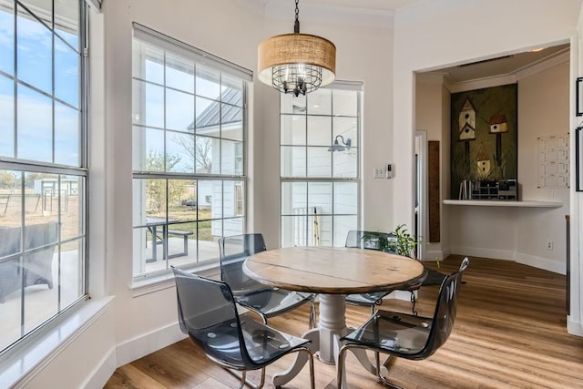 dining room featuring hardwood / wood-style flooring, plenty of natural light, and ornamental molding