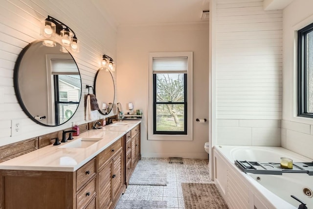 bathroom with a wealth of natural light, tile patterned flooring, vanity, and toilet