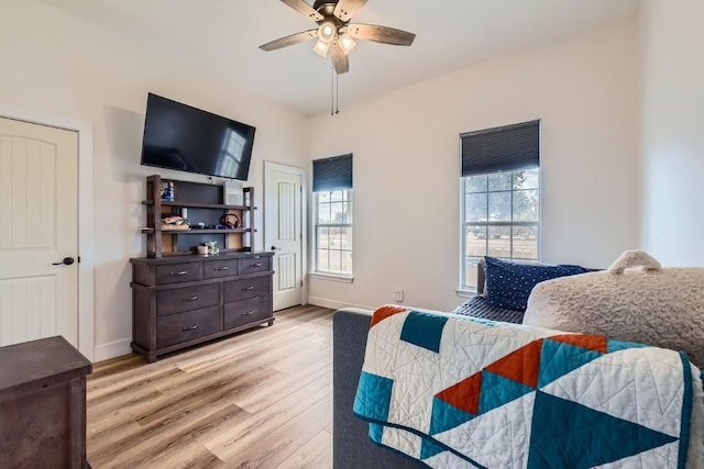 bedroom with ceiling fan, light wood-type flooring, and multiple windows