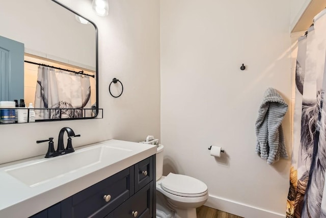 bathroom with vanity, toilet, and wood-type flooring