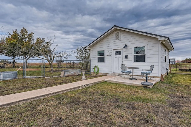 rear view of house featuring a patio area and a lawn