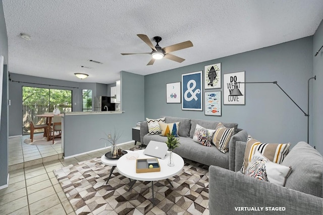 tiled living room featuring ceiling fan and a textured ceiling