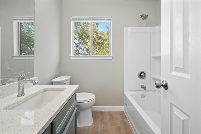 full bathroom featuring toilet, vanity, hardwood / wood-style flooring, and bathing tub / shower combination