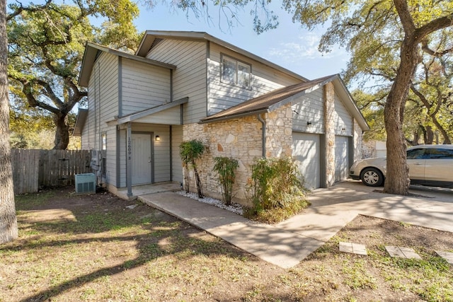 view of front of home with a garage and central AC