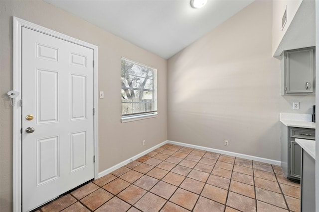 unfurnished dining area with light tile patterned floors and lofted ceiling