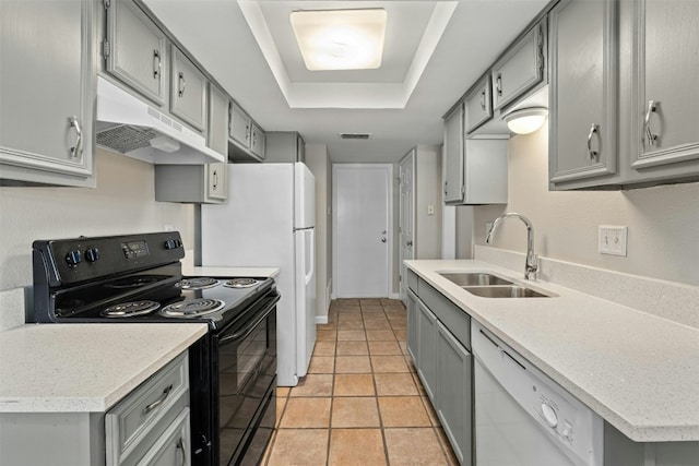 kitchen with black range with electric cooktop, a tray ceiling, white dishwasher, sink, and gray cabinets