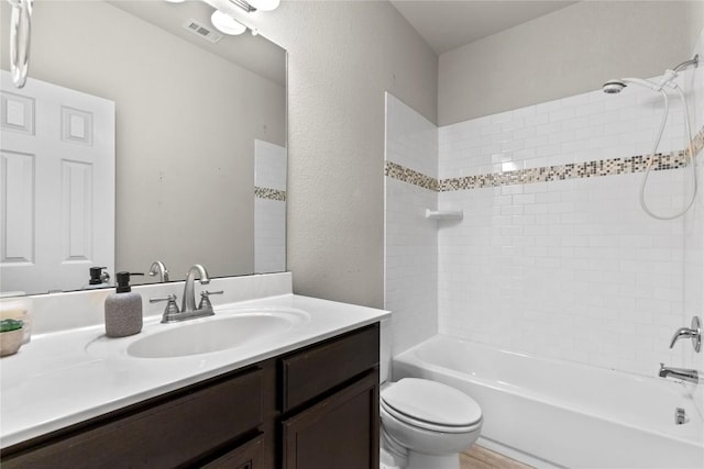 full bathroom with vanity, toilet, and tiled shower / bath combo