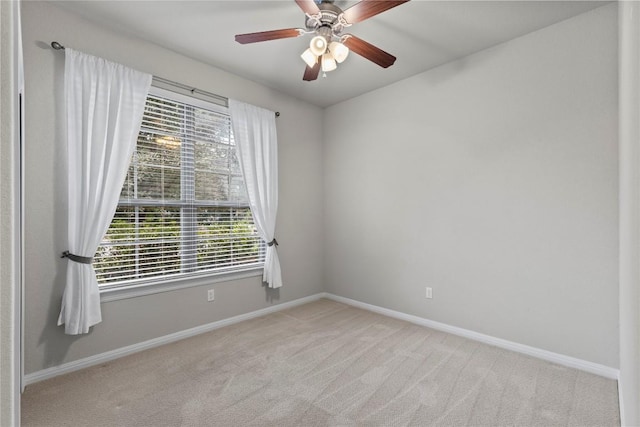 spare room featuring ceiling fan and light carpet