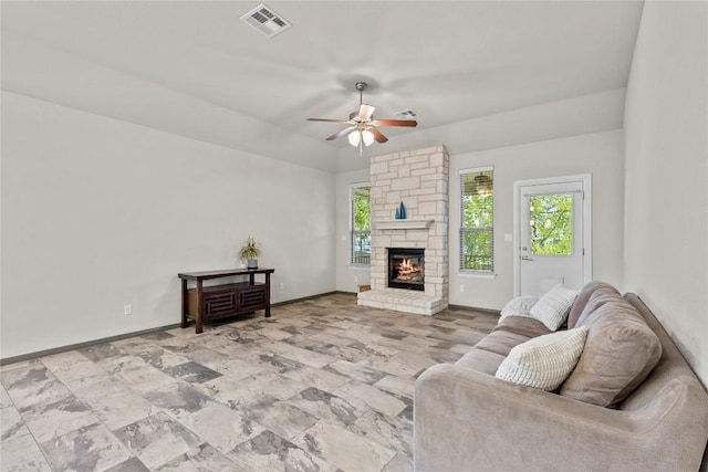 living room with ceiling fan and a fireplace