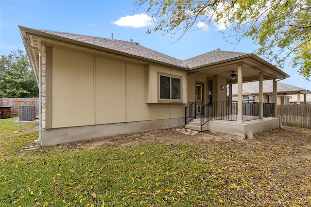 back of property featuring a lawn and central AC