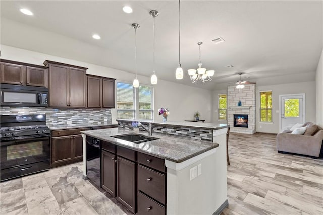 kitchen with black appliances, sink, tasteful backsplash, decorative light fixtures, and dark brown cabinets