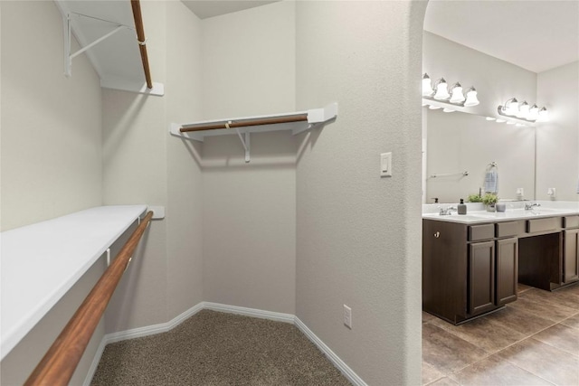 spacious closet featuring sink and light tile patterned floors