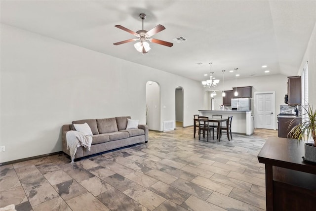 living room featuring ceiling fan with notable chandelier