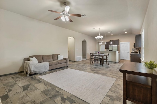 living area featuring visible vents, arched walkways, baseboards, and ceiling fan