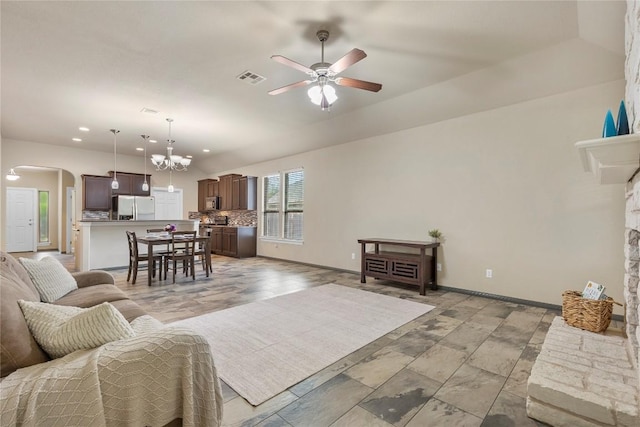 living room featuring arched walkways, ceiling fan with notable chandelier, recessed lighting, baseboards, and visible vents