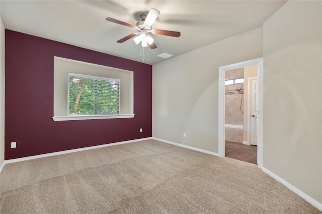 carpeted spare room featuring baseboards, ceiling fan, and visible vents