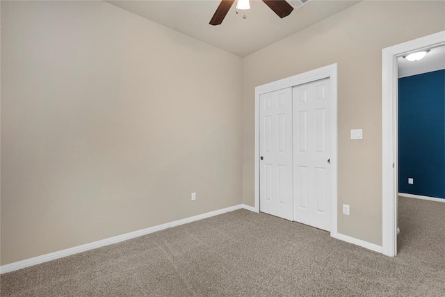 unfurnished bedroom featuring baseboards, ceiling fan, carpet, and a closet