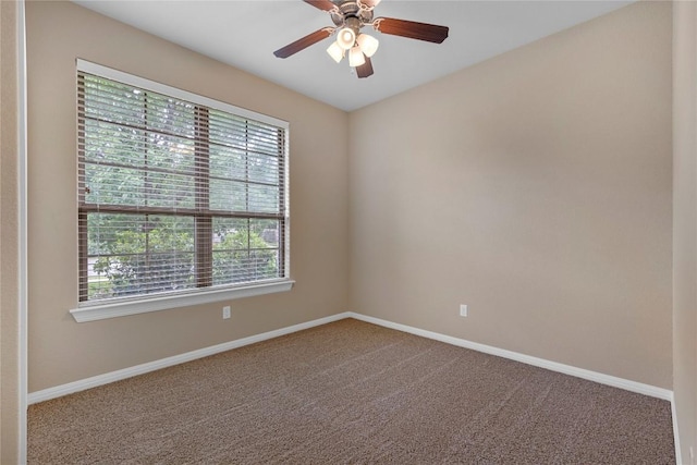 carpeted spare room featuring baseboards and ceiling fan