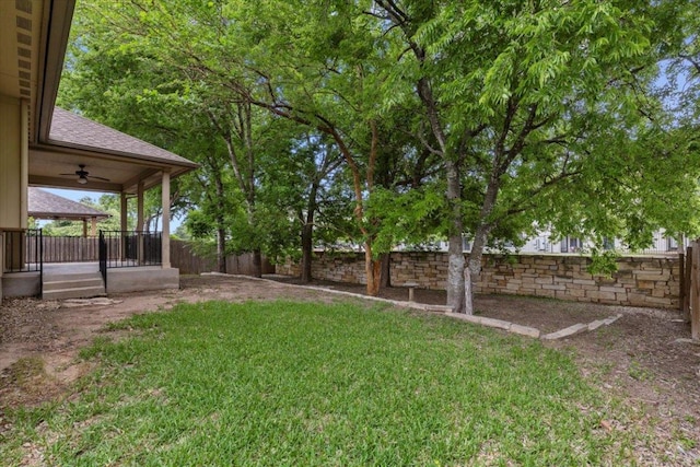 view of yard with a ceiling fan and a fenced backyard