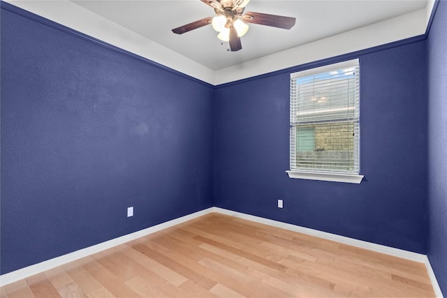 spare room featuring baseboards, a ceiling fan, and wood finished floors