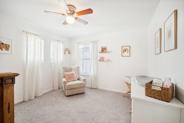 sitting room with ceiling fan and light colored carpet