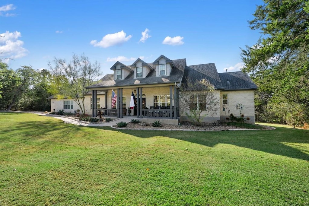 rear view of house with a lawn and a porch