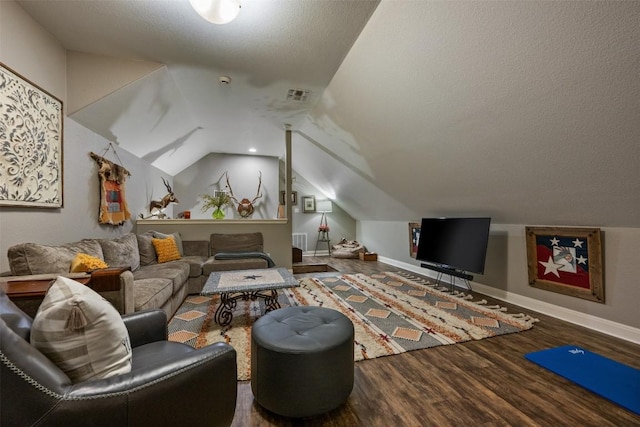 living room featuring hardwood / wood-style flooring, lofted ceiling, and a textured ceiling