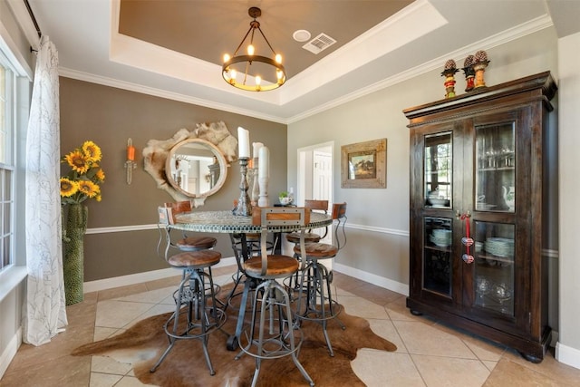 dining room featuring a chandelier, ornamental molding, a raised ceiling, and light tile patterned floors