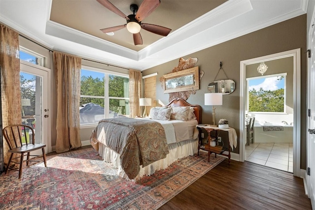 bedroom featuring ornamental molding, dark wood-type flooring, ceiling fan, and a tray ceiling