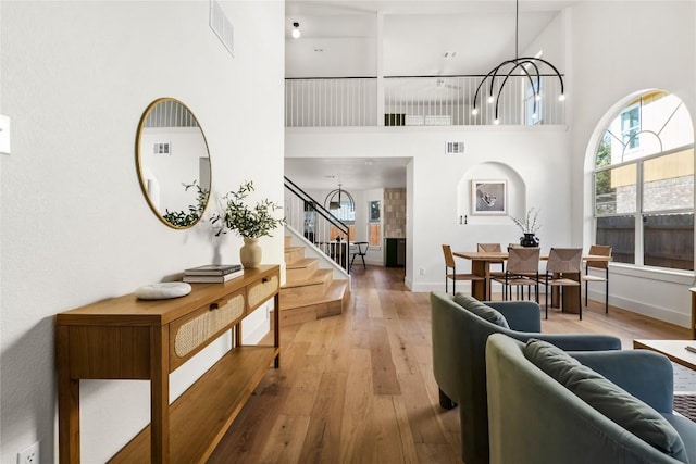 interior space featuring a high ceiling, hardwood / wood-style flooring, and a notable chandelier