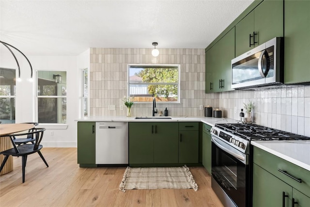 kitchen with light hardwood / wood-style flooring, stainless steel appliances, and green cabinetry