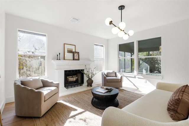 living room with hardwood / wood-style flooring, a wealth of natural light, and an inviting chandelier