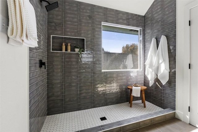 bathroom with tile patterned flooring and a tile shower