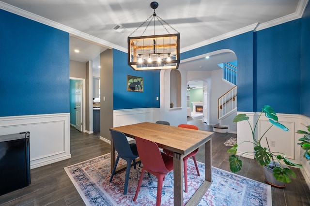 dining room with dark hardwood / wood-style floors, an inviting chandelier, and ornamental molding