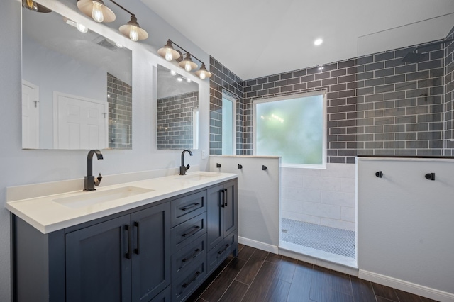 bathroom with vanity and a tile shower