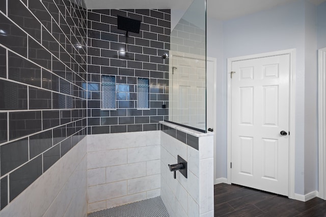 bathroom with hardwood / wood-style flooring and tiled shower