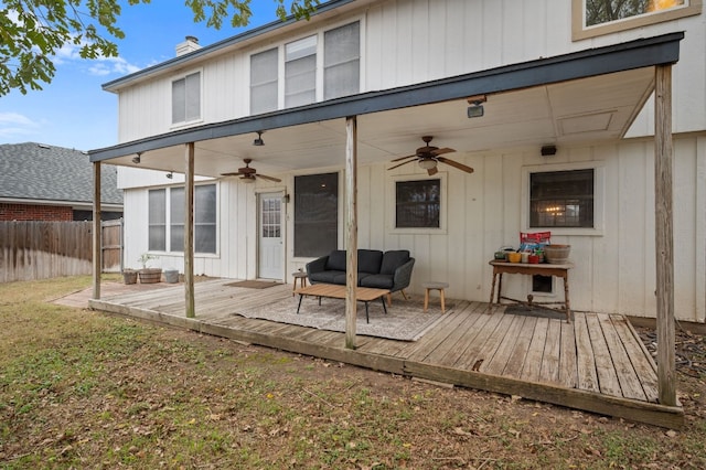 back of property with an outdoor living space, ceiling fan, and a deck