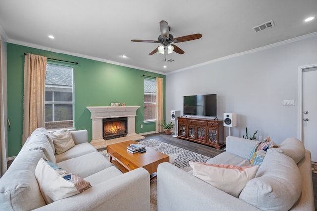 living room featuring hardwood / wood-style flooring, ceiling fan, and crown molding